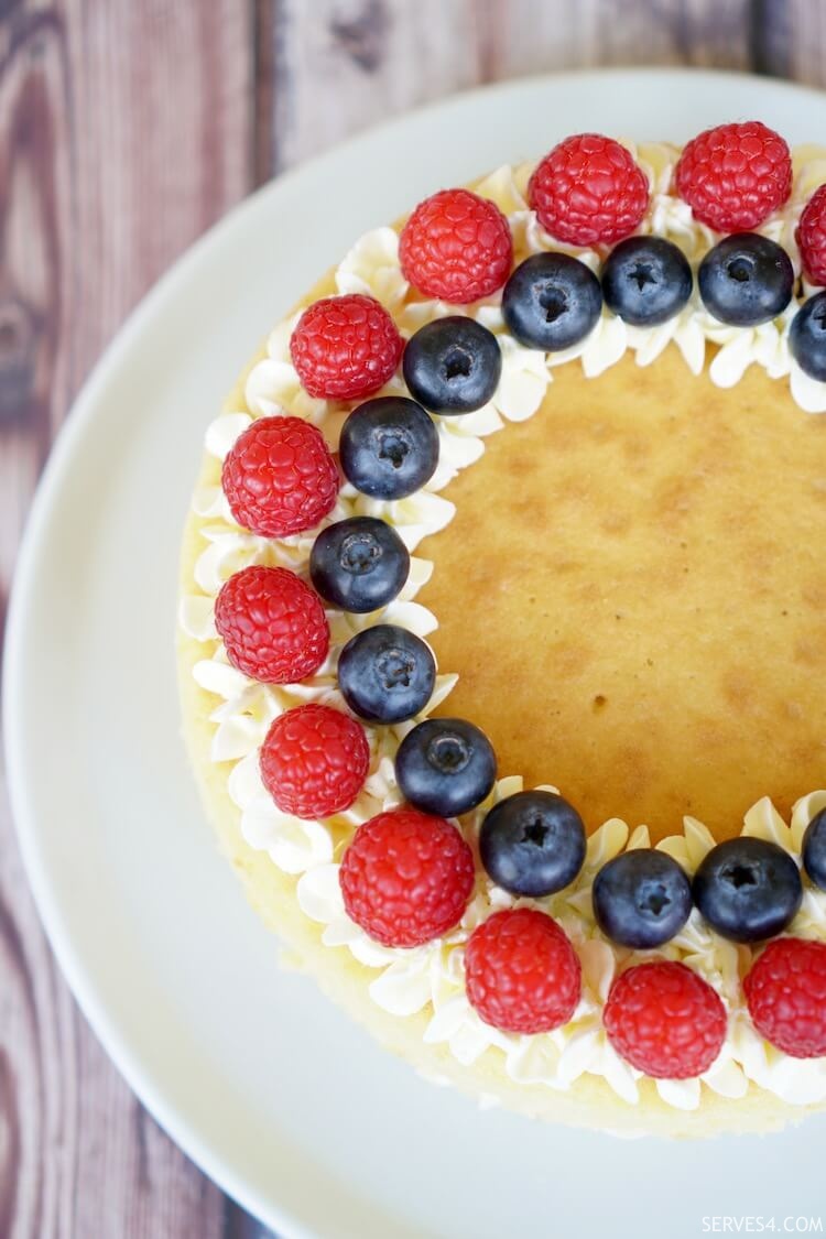 Victoria Sponge Cake Recipe with raspberry jam and fresh raspberries and blueberries on top